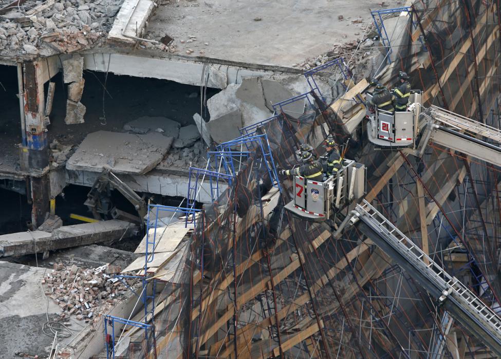 Emergency workers respond to a partial-building collapse on the
